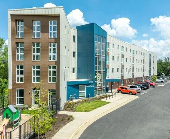 Amphora in Madison: a five-story building with a blue glass entry tower, playground and landscaped walk