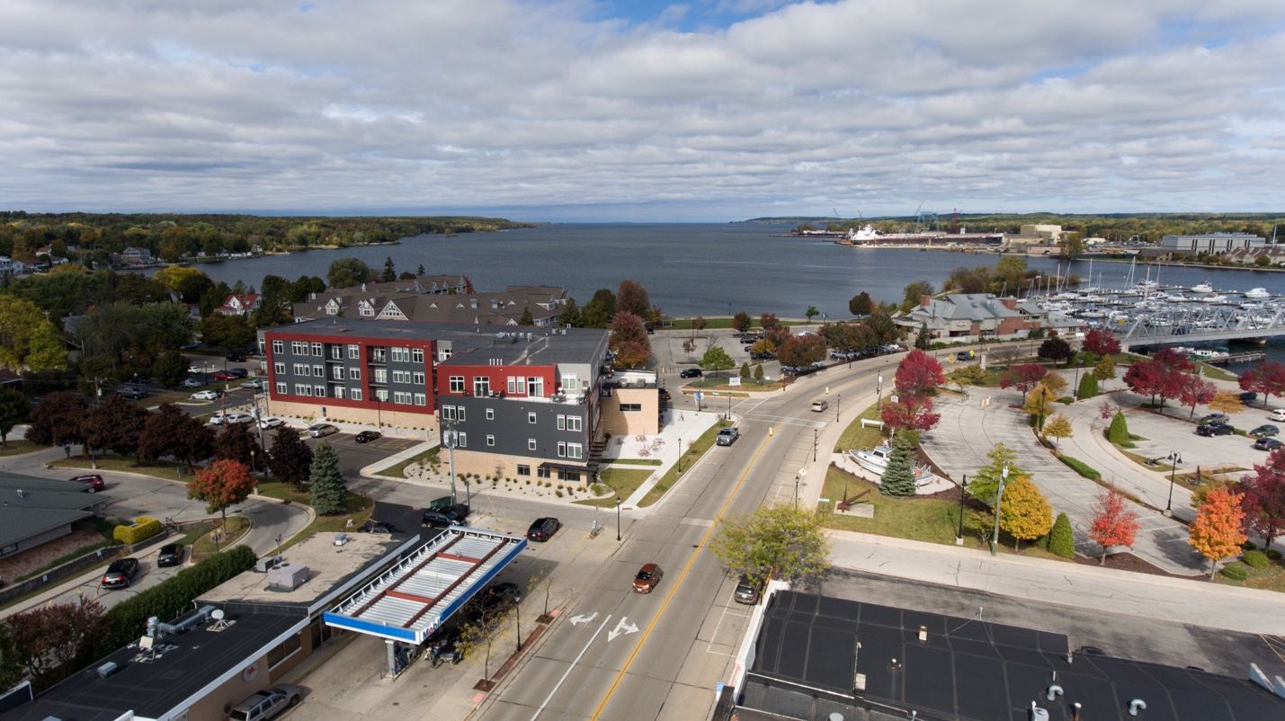 Aerial view of downtown Sturgeon Bay with a four-story mixed-use building near the waterfront
